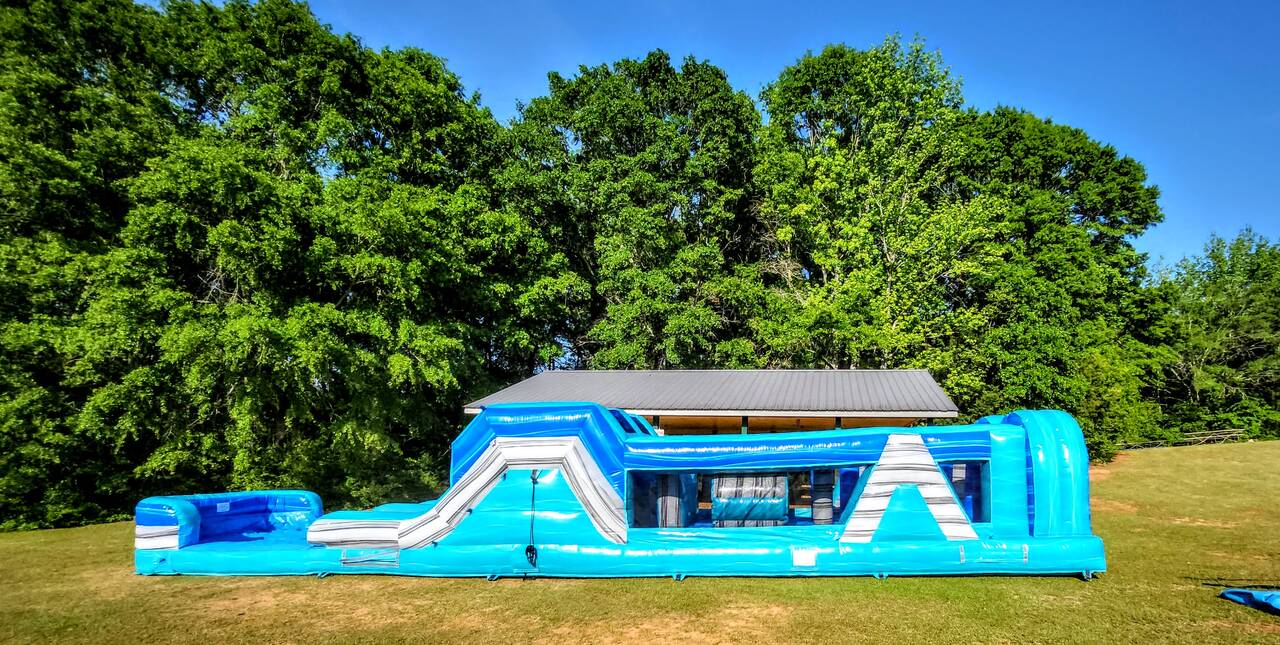Actual Wow Inflatables blue, teal, and green obstacle-course rental unit